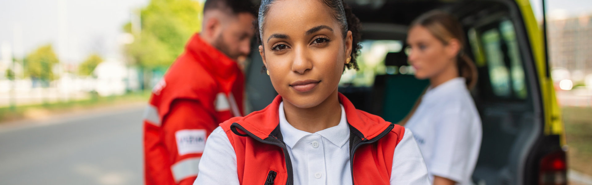 female african american paramedic standing rear of the ambulance